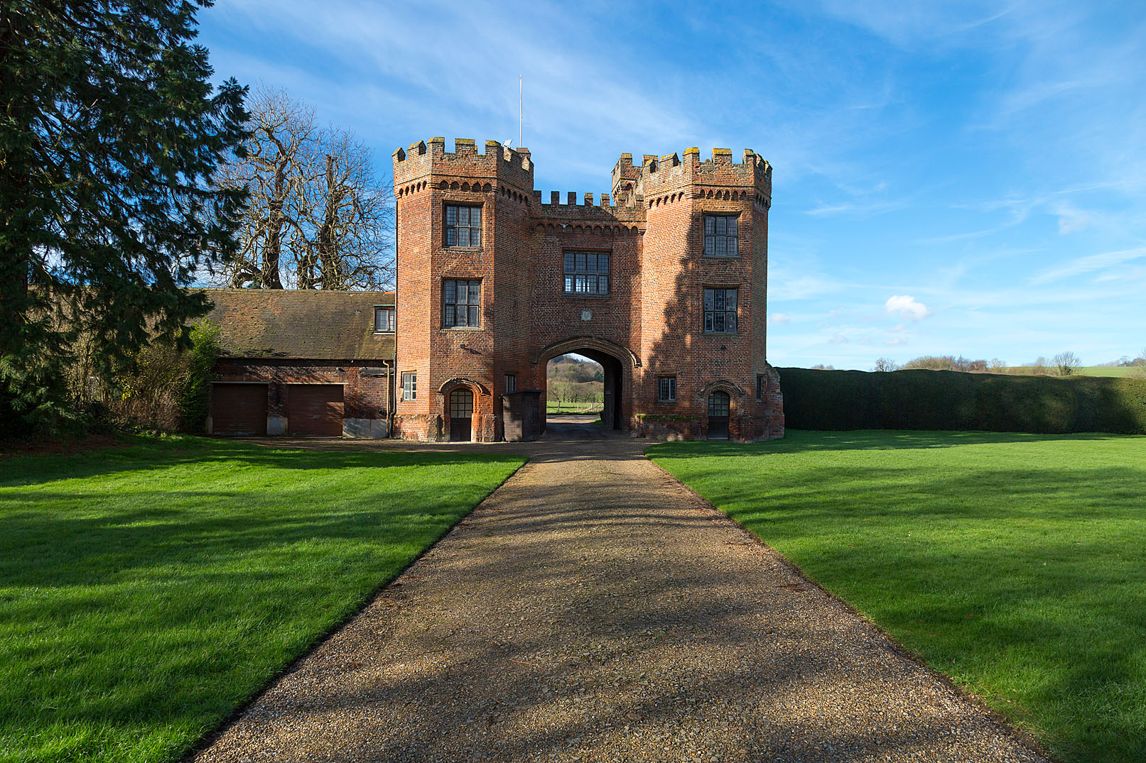 Red brick tudor gatehouse with path at the front