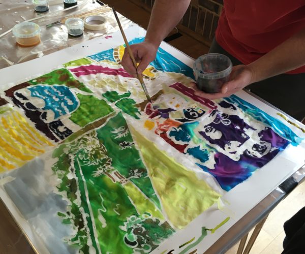 Hand painting landscape design onto silk